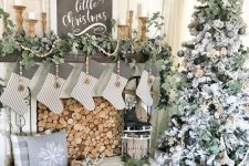 a vintage rustic Christmas mantel with a fresh greenery garland, wooden beads, striped stockings and lanterns in wooden candleholders