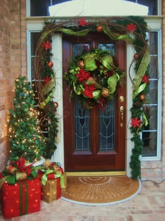 colorful Christmas styling in red and green, with an evergreen garland and wreath with touches of red and gold and a mini Christmas tree with lights and gift boxes