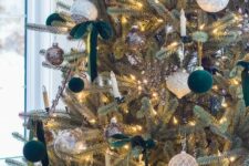 elegant and refined Christmas tree decor with white, silver and dark green velvet ornaments plus lights and dark green bows