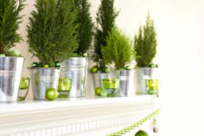 mantel decor with potted Christmas trees and green Christmas ornaments and a garland is amazing for the holidays