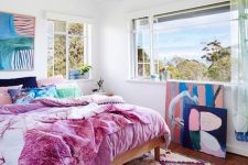 a bold bedroom with a colorful rug, bold bedding and lovely and bold artworks that create a mood in the room
