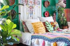 a bright boho bedroom with emerald walls, decorative baskets and colorful artworks, bold textiles and bedding is a real sanctuary