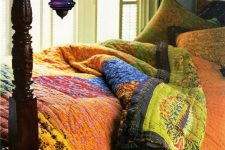 a colorful bedroom with a black carved bed and colorful bedding, colorful glass pendant lamps is a gorgeous idea for boho-loving people