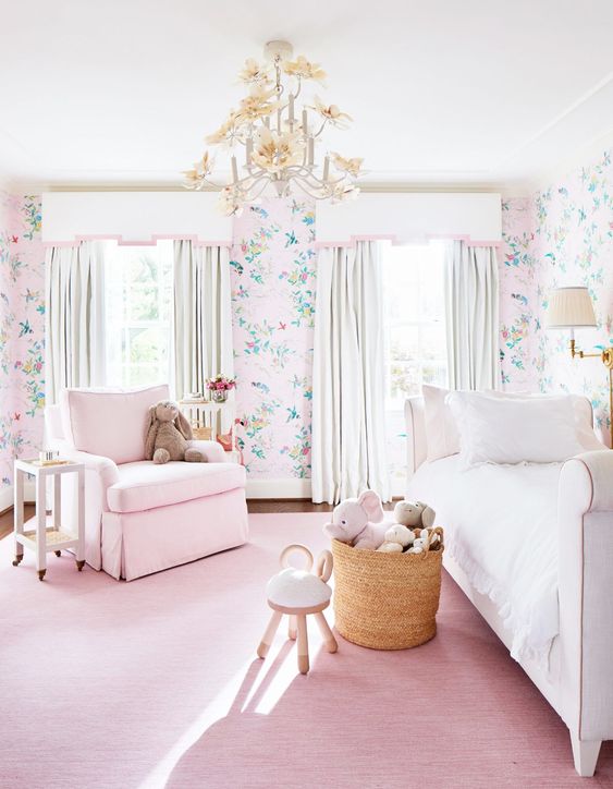 a cute and sweet girl's bedroom with floral wallpaper, a pink rug and a chair, an upholstered bed and a basket