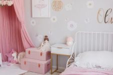 a dove grey girl’s room with white furniture, pink bedding, a pink teepee, pink suitcases and various toys is awesome