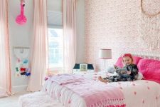 a fantastic pink boho girl’s bedroom with a pink wallpaper wall, light pink curtains, a bed with hot pink pillows and a hot pink rug