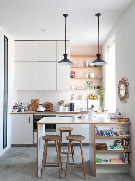 a modern white kitchen with open built-in shelves, a kitchen island with shelves and pendant lamps