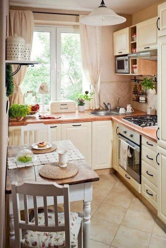 a neutral French country style kitchen with a tile backsplash, neutral textiles, a small table and floral chairs