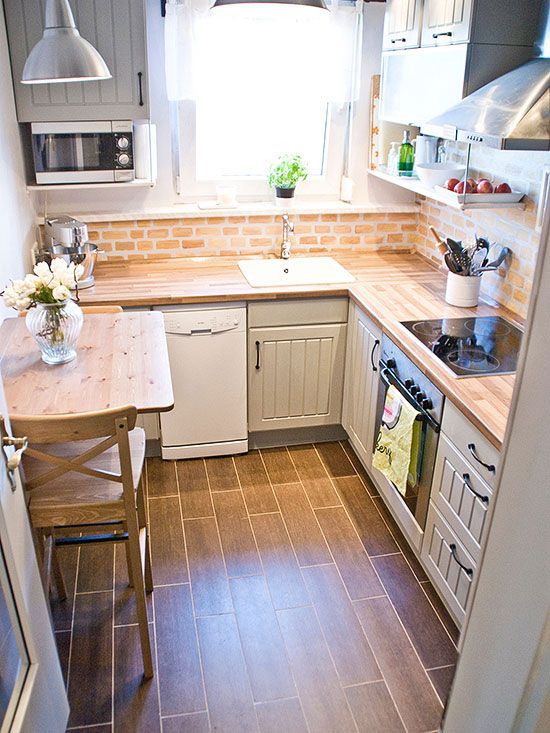 a neutral farmhouse kitchen with butcherblock countertops, a red brick backsplash and a tiny woodne table