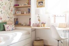 a pretty small girl’s room with built-in shelves, a bed with storage, a desk and a white chair, an elegant chandelier