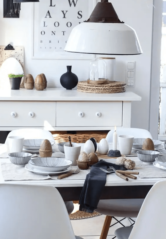 a Scandinavian Easter tablescape with patterned porcelain, dark napkins, simple cutlery and lots of eggs