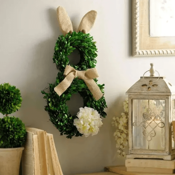 a boxwood bunny wreath with burlap ears and a bow and a fluffy tail is a super creative decoration for the front door, mantel or just wall