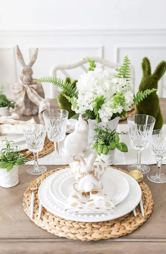 a charming Easter tablescape with a striped runner and polka dot napkins, woven placemats, greenery and white blooms plus binnes