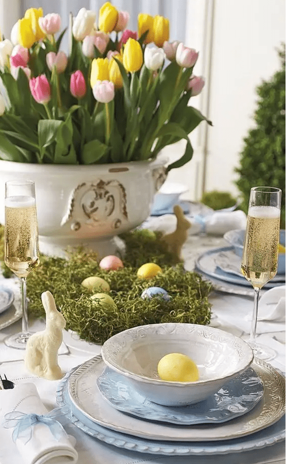 a chic Easter tablescape with a bold tulip centerpiece, moss with colorful eggs, blue porcelain and eggs
