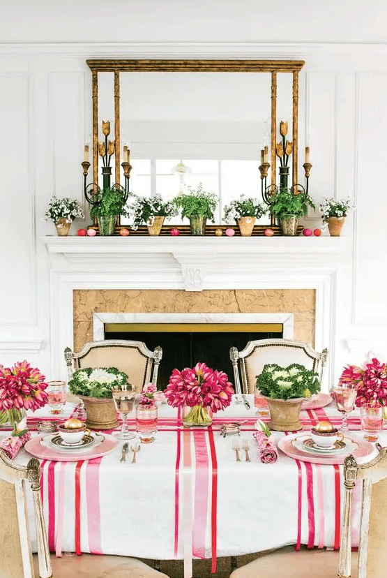 a colorful Easter table setting with striped and floral linens, bold blooms and cabbage, colorful glasses