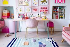 a colorful home working space with a blue fringe rug, a pink desk and a pink chair, a pink litter bin and a pink accent wall with colorful artwork is pure fun