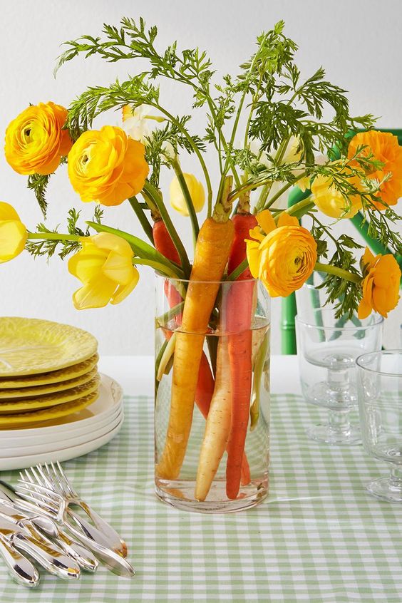 a cool and cute Easter centerpiece of yellow ranunculus and tulips plus carrots is a gorgeous decoration and you can make it fast