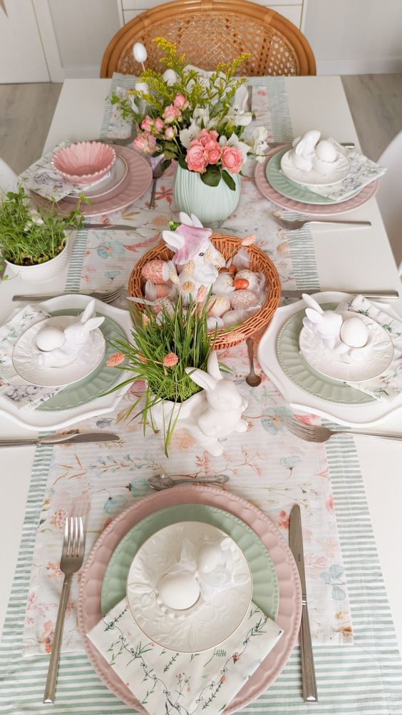 a lively Easter tablescape with an egg and bunny centerpiece, pink tulips and ranunculus, blush and green plates, printed linens
