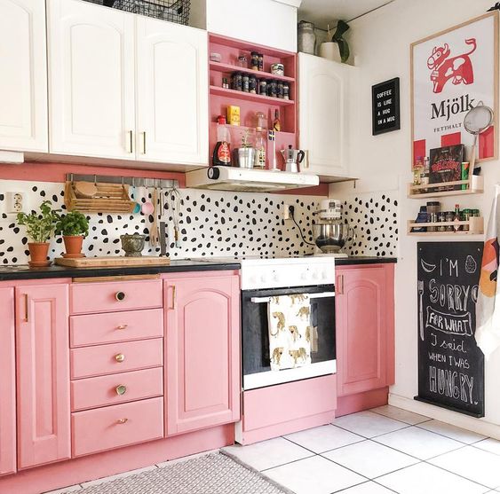 a playful kitchen with pink and white cabinetry, a Dolmatin backsplash and brass handles and fixtures is bold and cool