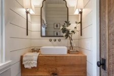 a rustic butcher’s countertop makes a statement in this powder room, and baskets under it add a cozy feel