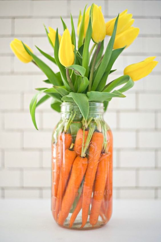 A simple last minute Easter centerpiece of carrots and yellow tulips is a cool decoration for spring