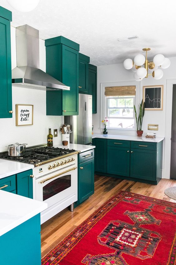 a teal kitchen with white countertops, a backsplash and a bold boho rug plus a retro lamp is a cool idea