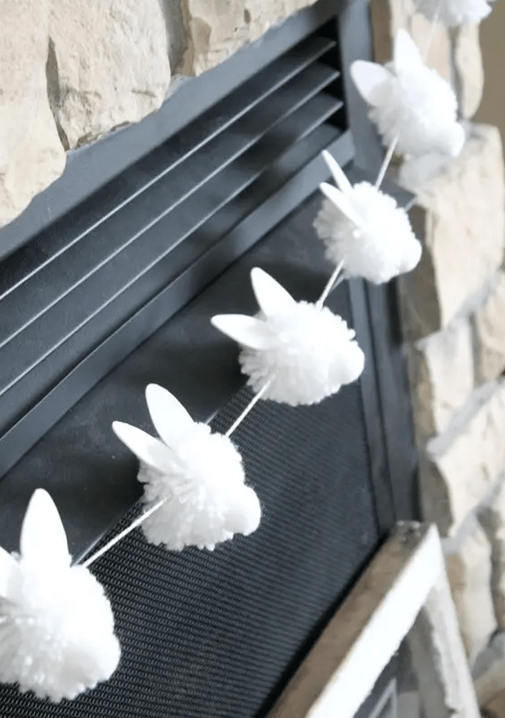 a white pompom bunny garland screams hoppy Easter is a super fun and cool decor idea that you can realize yourself