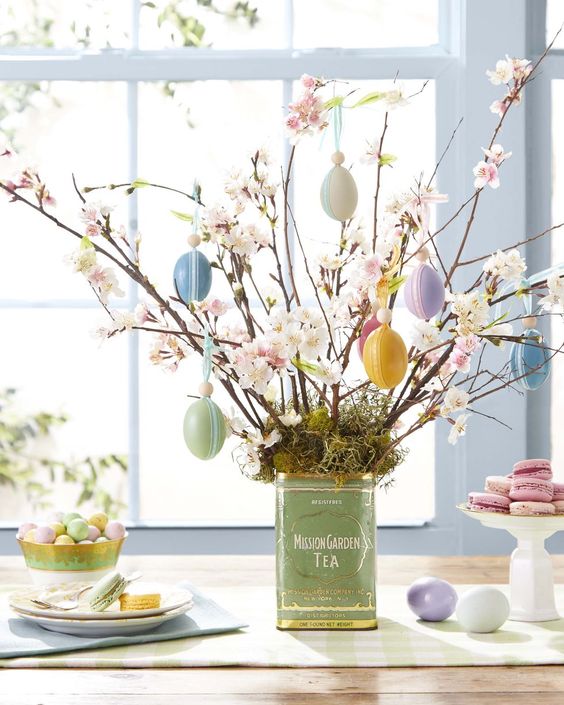 an Easter centerpiece of faux blooming branches with pastel eggs and moss is a cool decoration for spring or Easter
