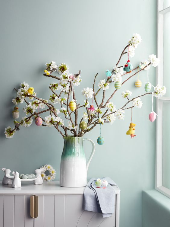 Faux blooming branches decorated with pastel colored plastic eggs and a chick are a cool Easter tree to try