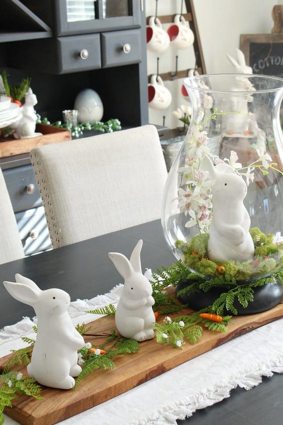 lovely bunny Easter decor with a wooden tray, greenery and carrots and some bunny figurines can be used as a centerpiece