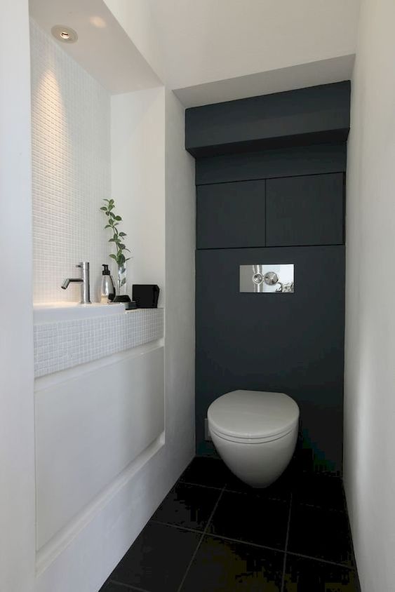 a black and white guest toilet with a built-in sink, some built-in lights and even storage