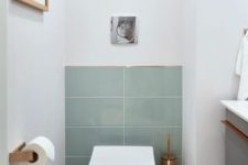 a laconic guest toilet with aqua tiles, copper touches and a floating vanity with a sink