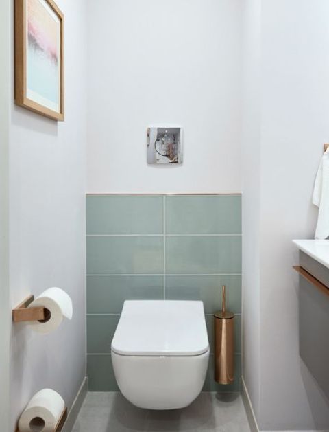 a laconic guest toilet with aqua tiles, copper touches and a floating vanity with a sink