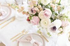 a delicate Mother’s Day table setting with pastel and neutral blooms, grey and white plates and blush napkins