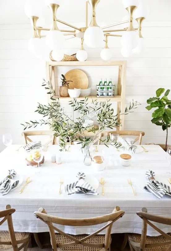 a fresh farmhouse tablescape with striped napkins, an olive branch centerpiece and gold cutlery is cool for Mother's Day