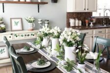 a fresh spring tablescape with a striped table runner, black matte chargers, white porcelain and white tulips centerpieces
