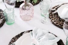 a neutral spring tablescape with pastel glasses and blooms is added drama with dark wicker chargers