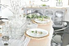 blooming branches in glass bottles and a wicker basket, blooming branch card holders, a striped runner for a neutral spring look
