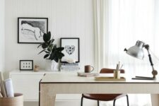 a stylish neutral home office with a plywood desk, a cabinet on the wall, a leather chair, some artworks