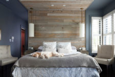 an enjoyable bedroom with a navy and grey part separated with a large weathered wood roof over the bed, grey bedding and creamy furniture
