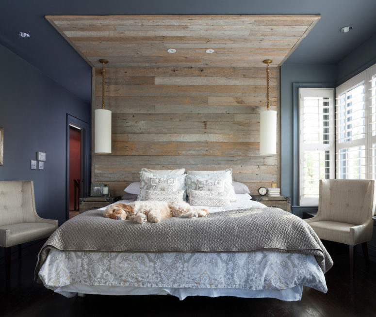 an enjoyable bedroom with a navy and grey part separated with a large weathered wood roof over the bed, grey bedding and creamy furniture