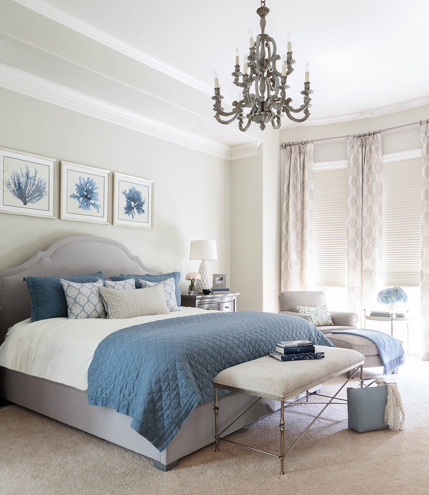 A sea inspired bedroom with a grey floor, walls, curtains and an upholstered bed plus blue textiles and artworks