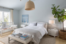 a creamy, dove grey and light blue bedroom with a wicker lampshade, some grey textiles and creamy furniture