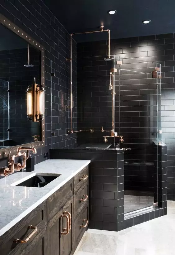 A black bathroom with subway tiles, a white floor, a dark stained vanity with a white countertop and a mirror in a wooden frame