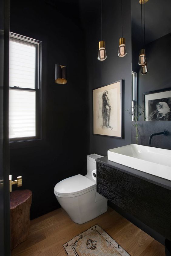 a black vintage powder room with a black floating vanity, white appliances, a cluster of pendant bulbs and a vintage artwork