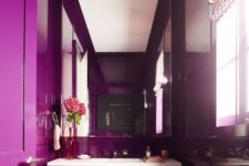 a bright contemporary bathroom done in purple, with an oversized mirror and a floatign sink plus printed shades