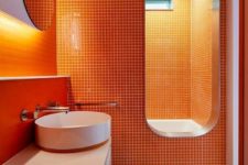 a bright modern bathroom with orange tiles on walls and a neutral floor, it’s a chic and bold idea