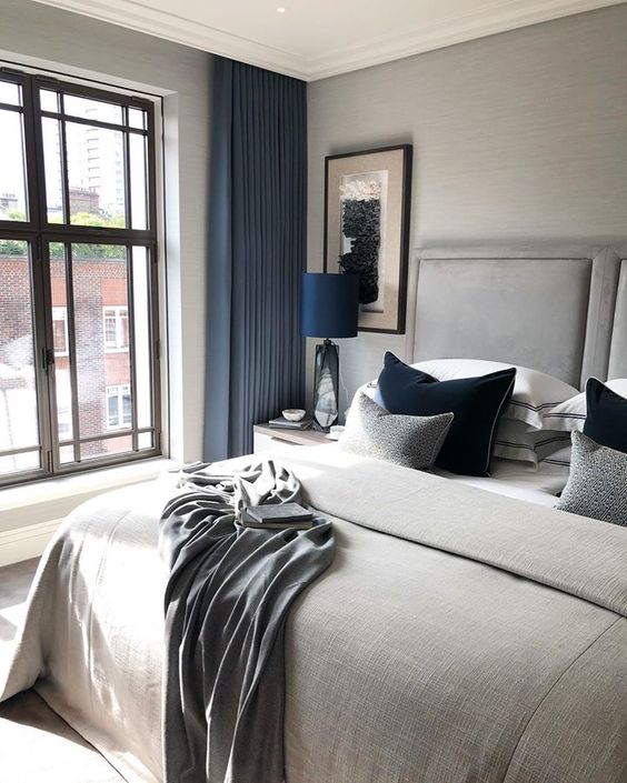 a dove grey bedroom with bold blue touches shows off luxury and beauty