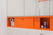 a floating mirror with a storage compartment done in orange is a non-typical way to add color to your space