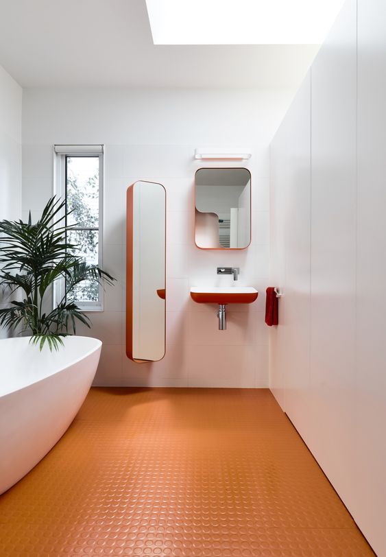 a minimalist bathroom with an orange penny tile floor and orange edges is a bold and chic idea